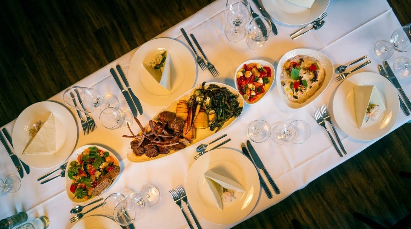 Festlich gedeckte Tafel mit Platten und Salaten aus der Vogelperspektive