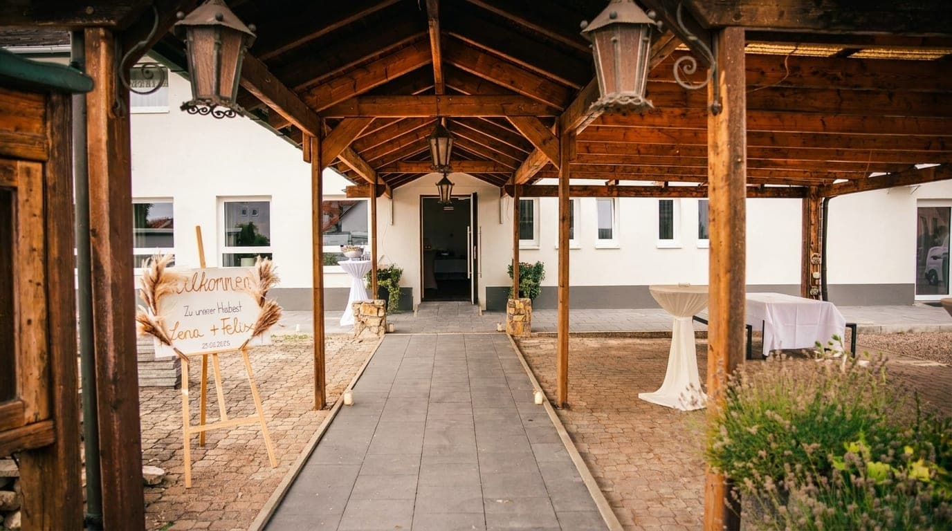 Hölzerner Pergola-Eingang mit Laternen und Willkommensschild zur Feier