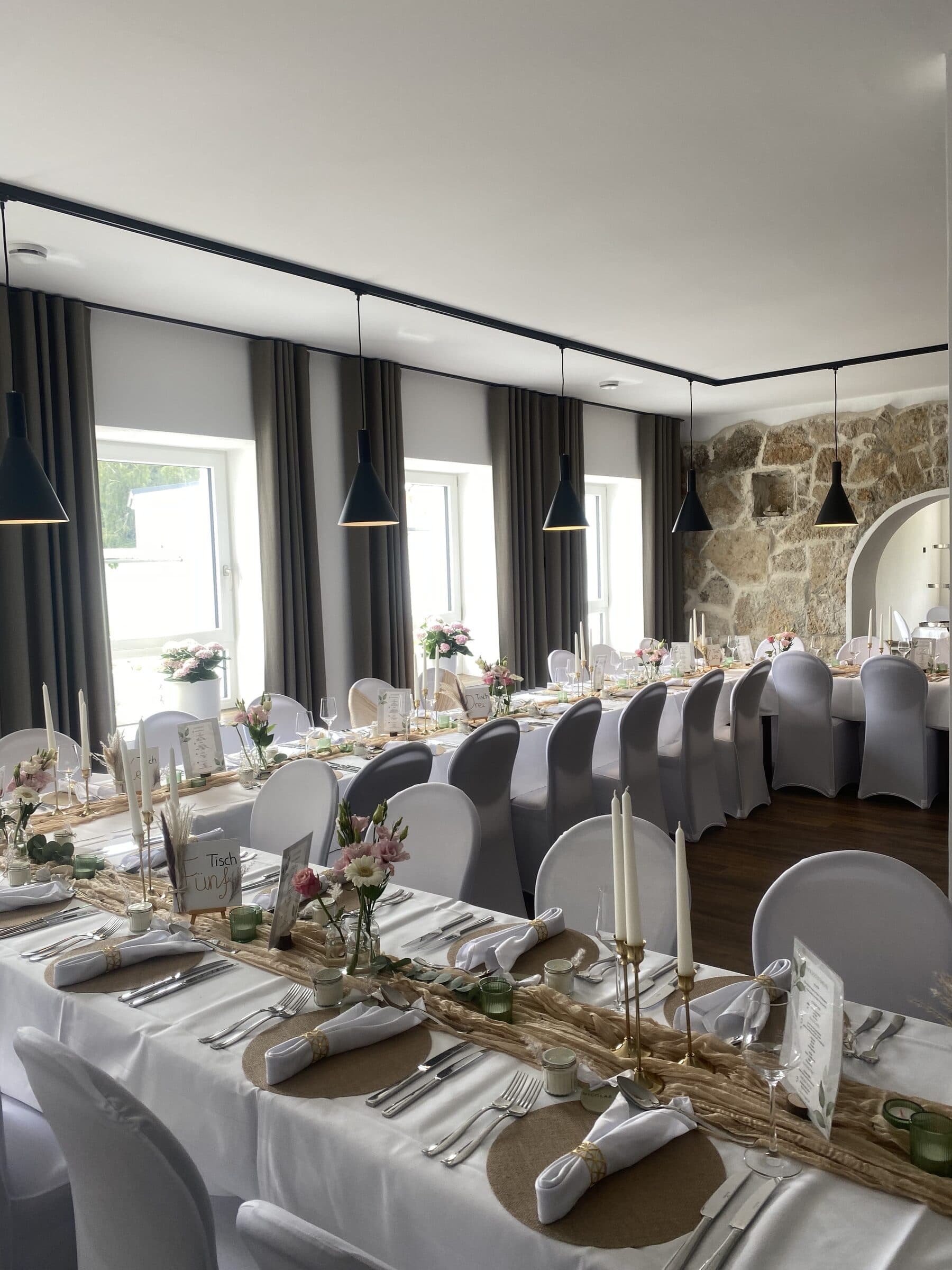 Festlich gedeckte Hochzeitstafeln mit weißen Hussen im Saal der KnochenMühle